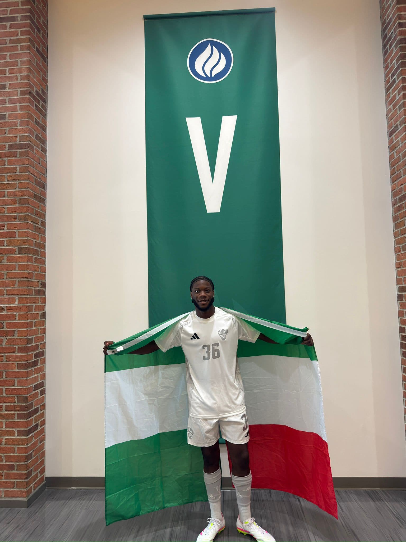 Valentino holding the Nigeria and Italy flags in a soccer jersey